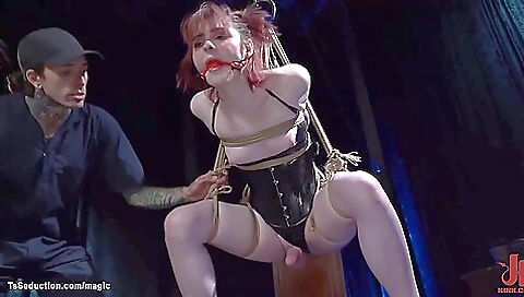 Redheaded girl in a tight harness hangs on a huge one